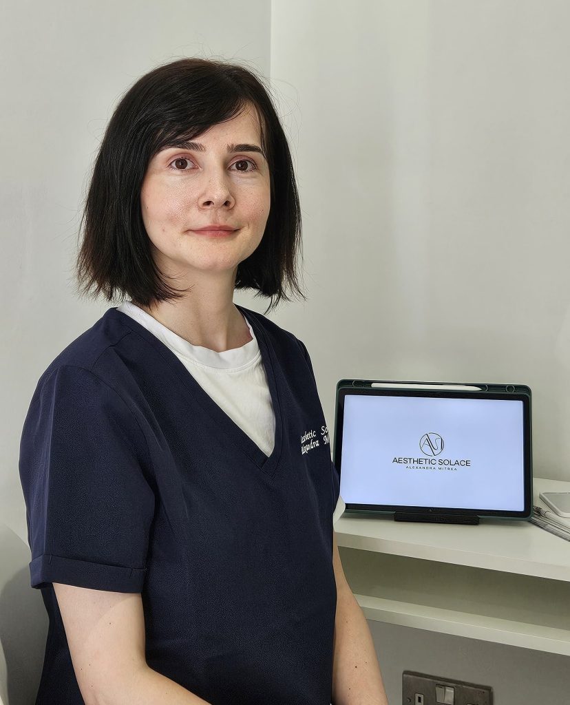 Aesthetic Practitioner Alexandra Mitrea awaiting her next client in the aesthetic room, wearing the business branded scrubs.